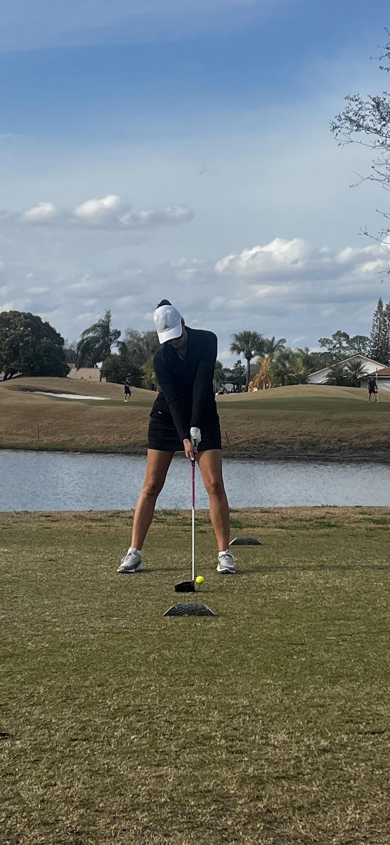 Woman golfer teeing off